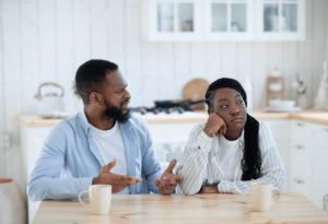 black couple arguing at the kitchen counter after she engaged in infidelity